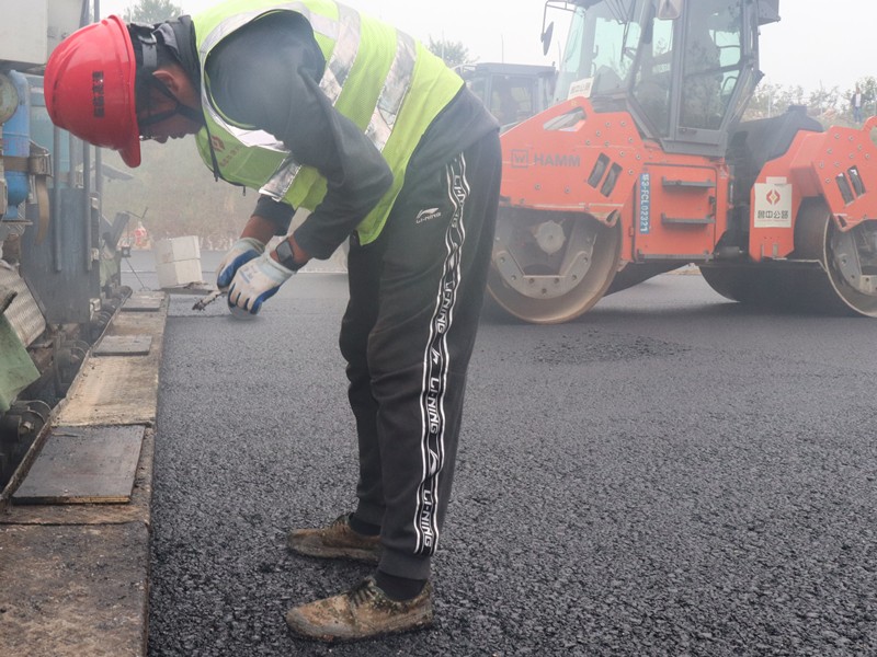 5、油層施工員任慶波隨時(shí)測量瀝青層松鋪厚度_副本